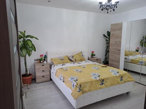 a bedroom with a bed with a yellow bedspread at Mareto House in Turda
