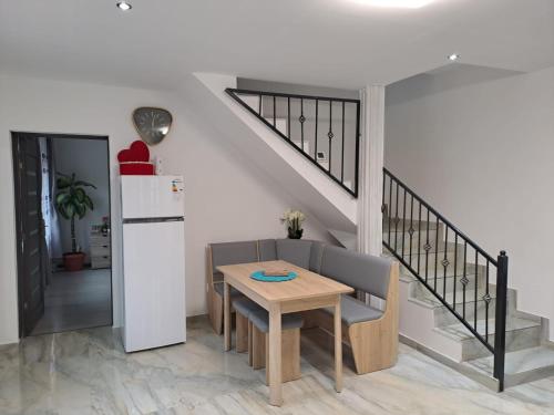 a dining room with a table and a staircase at Mareto House in Turda