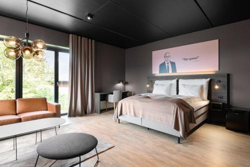 a bedroom with a bed and a couch and a table at Hotell Jæren in Bryne