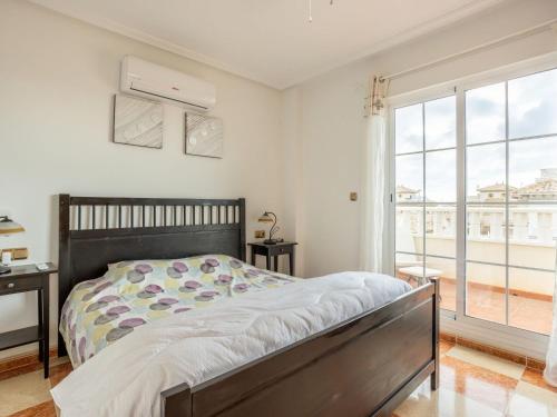 a bedroom with a bed and a large window at Terraced Home in Cabo Roig in Cabo Roig