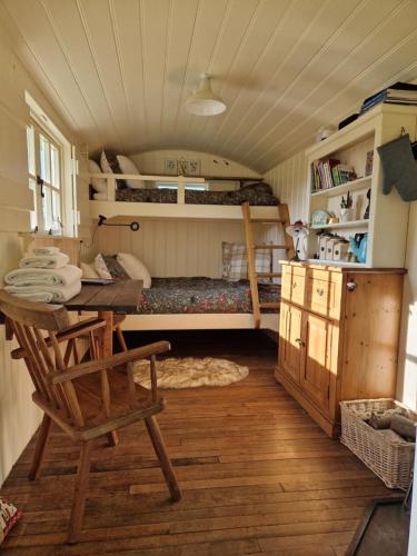 Zimmer mit einem Schreibtisch und einem Bett in einem Zimmer in der Unterkunft The Delkin Shepherds Huts Castle Combe in Castle Combe