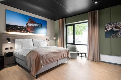 a bedroom with a bed and a large window at Hotell Jæren in Bryne