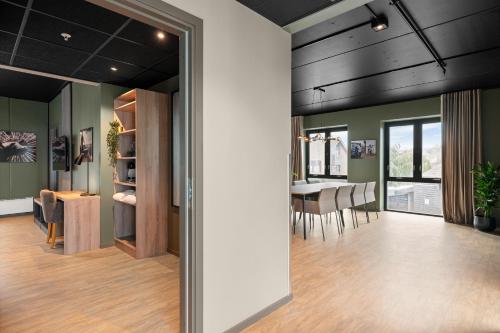 a dining room and living room with a table and chairs at Hotell Jæren in Bryne