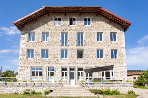 a large stone building with stairs in front of it at LA BATISSE l'arbre gris in Le Grand-Abergement