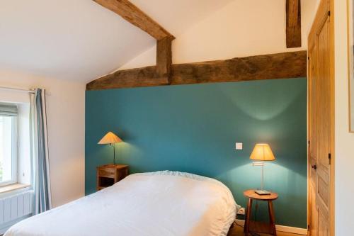 een slaapkamer met een blauwe muur en een bed bij Gîte des Pilliers in Belleville-sur-Saône