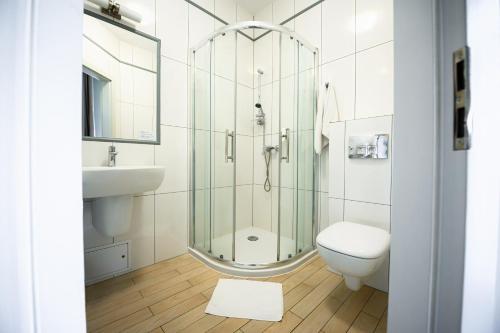 a bathroom with a shower and a toilet and a sink at Hotel Kazimierz III in Kraków