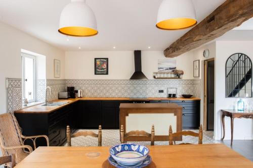a kitchen with a wooden table and a dining room at Gîte des Pilliers in Belleville-sur-Saône
