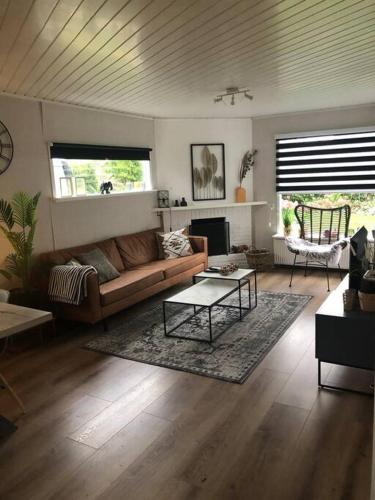 a living room with a couch and a table at Heerlijk huisje op de Veluwe in Ermelo