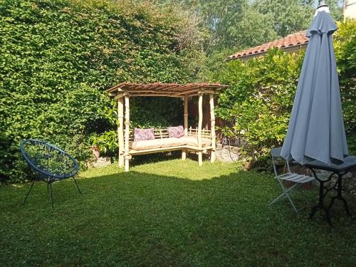 um jardim com um gazebo e um guarda-sol em Maison en pierre restaurée avec jardin em Auch