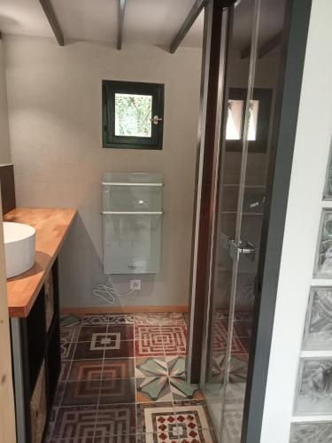 a bathroom with a shower and a tile floor at Maison en pierre restaurée avec jardin in Auch