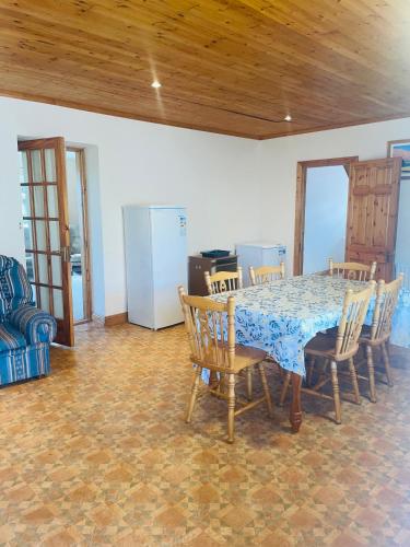 uma sala de jantar com uma mesa e cadeiras e um frigorífico em Clonmines lodge em Wexford