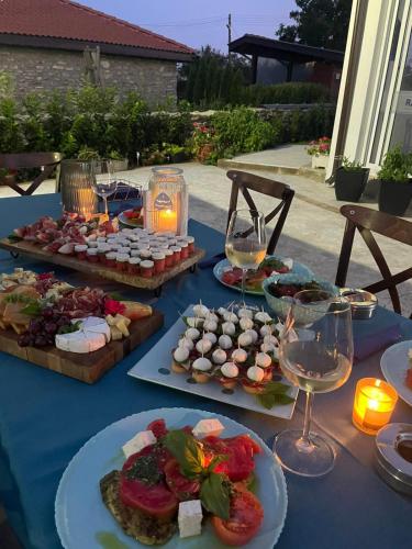a blue table with plates of food and glasses of wine at Комплекс Радост in Ezerets
