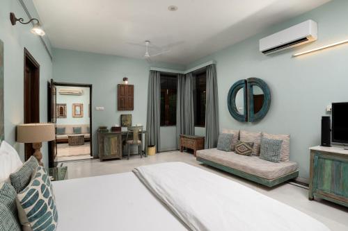 a bedroom with a bed and a couch and a mirror at The Almond Tree in Jodhpur