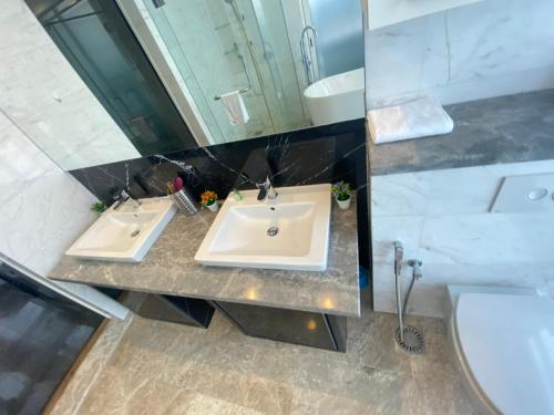 a bathroom with two sinks and a large mirror at KLCC Sky Villa Suites Platinum in Kuala Lumpur