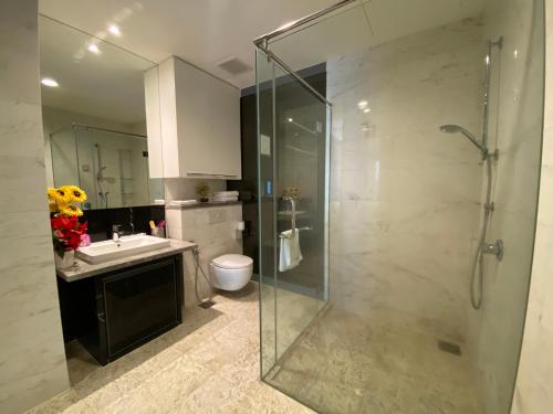 a bathroom with a glass shower and a sink at KLCC Sky Villa Suites Platinum in Kuala Lumpur