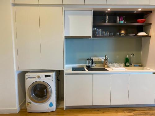 a kitchen with a washing machine in a white kitchen at KLCC Sky Villa Suites Platinum in Kuala Lumpur