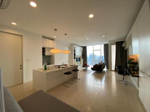 a large kitchen with a counter and a living room at KLCC Sky Villa Suites Platinum in Kuala Lumpur