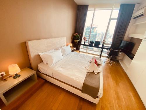 a bedroom with a white bed and a large window at KLCC Sky Villa Suites Platinum in Kuala Lumpur