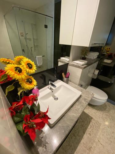a bathroom with a sink and flowers on a counter at KLCC Sky Villa Suites Platinum in Kuala Lumpur