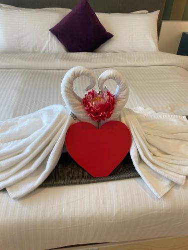 a bed with two swans with a heart on it at KLCC Sky Villa Suites Platinum in Kuala Lumpur