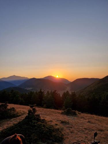 a sunset on a hill with the mountains in the background at Le Silence du Midi in Comus