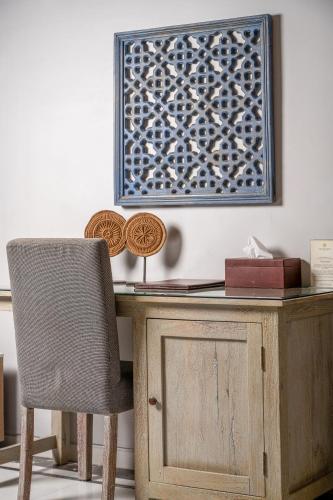 a wooden desk with a chair and a picture on the wall at The Almond Tree in Jodhpur