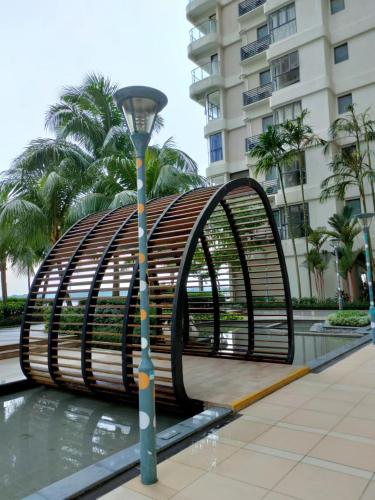 a metal bench with a street light in front of a building at 2 Seaview Balcony@Danga Bay in Johor Bahru
