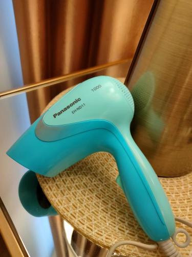 a blue hair dryer sitting on top of a chair at 2 Seaview Balcony@Danga Bay in Johor Bahru
