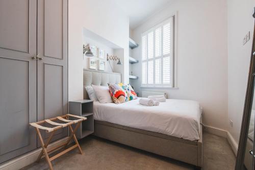 a small bedroom with a bed and a window at Pass the Keys - Modern & Stylish Garden Home in Islington in London