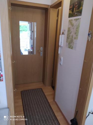 a hallway with a door and a rug next to a door at Tiny Flat Baiersbronn in Baiersbronn