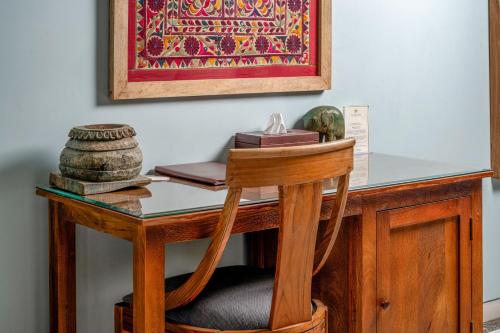 a wooden desk with a wooden chair at a table with a picture at The Almond Tree in Jodhpur