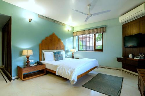 a bedroom with a bed and a flat screen tv at The Almond Tree in Jodhpur