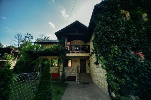 a house with a stone wall and a gate at Pensiunea Casa Dacilor in Podeni