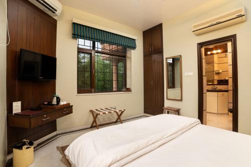 a bedroom with a large bed and a television at The Almond Tree in Jodhpur