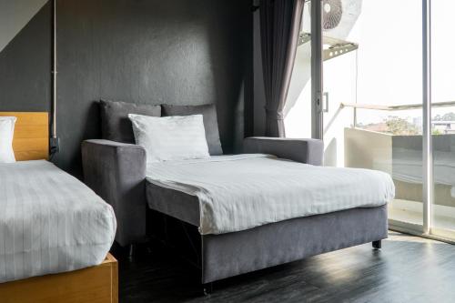 a bedroom with two beds and a large window at Get Zleep Premium Budget Hotel in Chiang Mai
