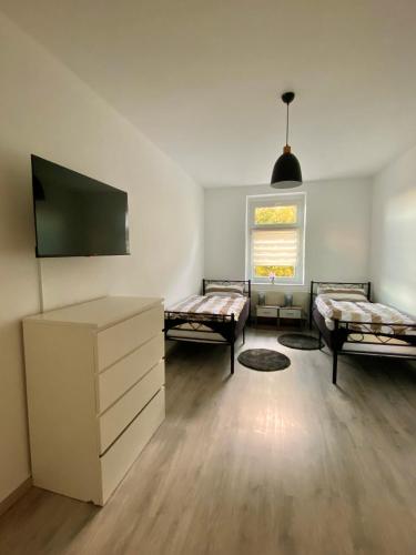 ein Wohnzimmer mit 2 Betten und einem TV in der Unterkunft Gemütliche 3-Zimmer Ferienwohnung in Leipzig 1 OG in Leipzig