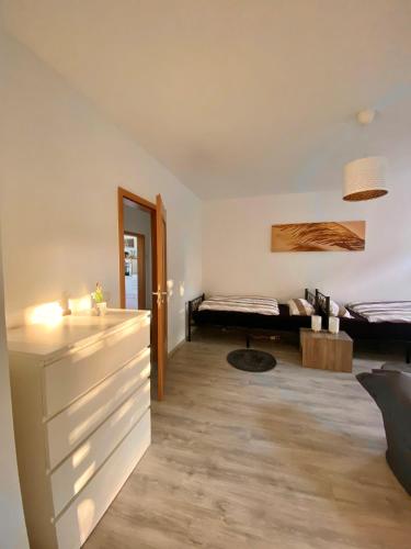 ein Wohnzimmer mit einem Bett im Hintergrund in der Unterkunft Gemütliche 3-Zimmer Ferienwohnung in Leipzig 1 OG in Leipzig