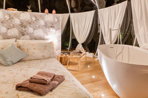 ein Badezimmer mit einer Badewanne, einem Bett und einer Badewanne in der Unterkunft Il Cantico Bubble Room Home Restaurant in San Giacomo