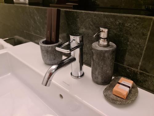 lavabo con grifo y jabón en Lucerne Lake View Apartments en Lucerna
