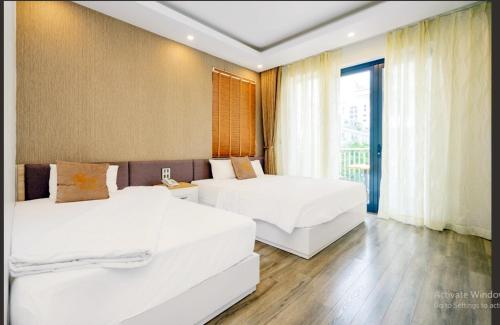 a hotel room with two beds and a window at BBQ HOSTEL in Ha Long