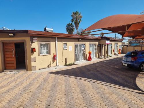 a building with a car parked in a parking lot at Ethen Guesthouse in Polokwane