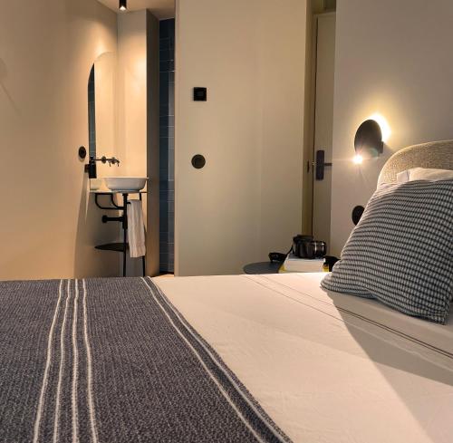 a bedroom with a bed and a bathroom with a sink at SUTRooms in Braga