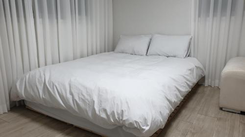 a bed with white sheets and pillows in a bedroom at Seoul Vibes in Seoul