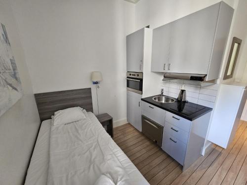a small kitchen with a bed and a sink at Keybutler Royal Park Studios in Oslo
