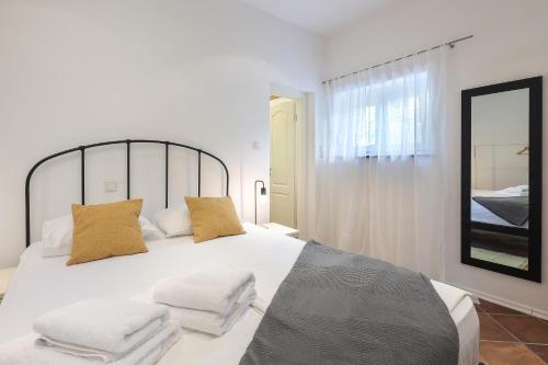 een slaapkamer met een wit bed met 2 kussens bij Apartment FERIA 1 in Opatija