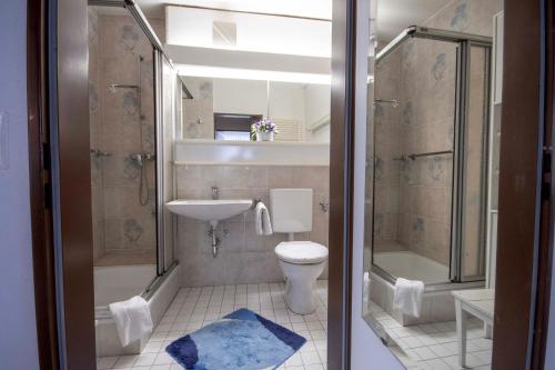 uma casa de banho com um WC, um chuveiro e um lavatório. em Frische Brise FeWo 12 01 em Cuxhaven