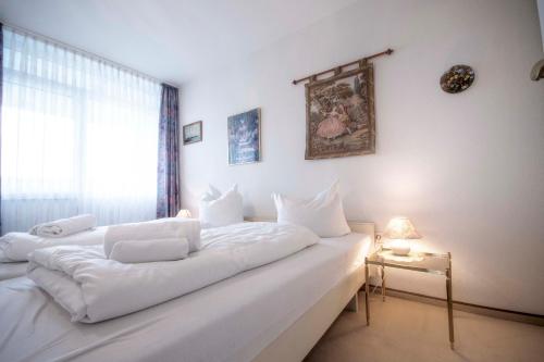 um quarto com 2 camas brancas e uma janela em Frische Brise FeWo 12 01 em Cuxhaven
