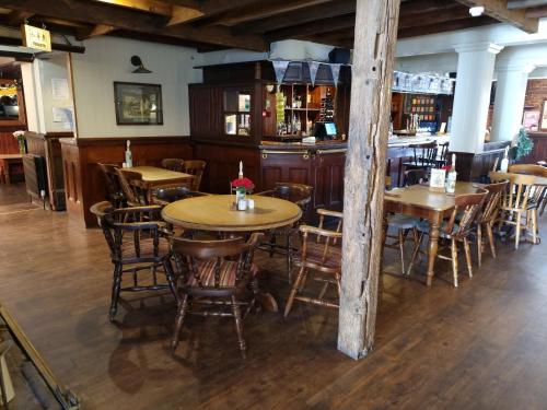 un restaurante con mesas y sillas de madera y un bar en The Bugle Inn, en Southampton