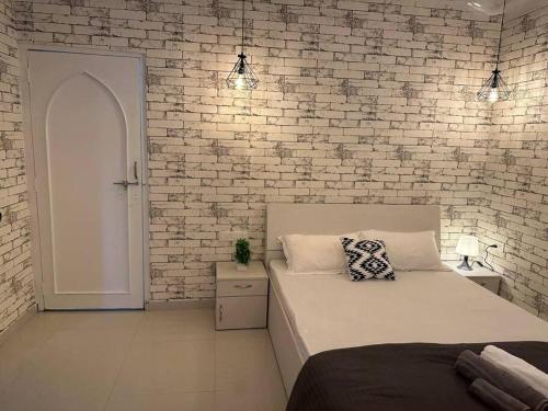 a bedroom with a bed and a brick wall at Boutique Room in Koregaon Park. WiFi, Ac, Smart Tv in Pune