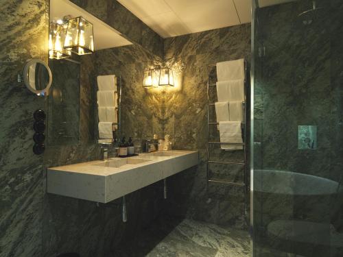 a bathroom with a sink and a shower and a mirror at Victory Hotel in Stockholm